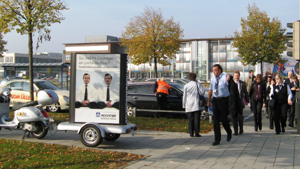Messemarketing mit einem Werbeanhänger am Messeeingang