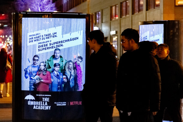 Filmfans schauen auf CLP-Mover mit The Umbrella Academy Plakat