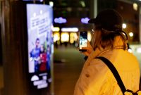 clp-mover-streamingdienst-netflix-the-umbrella-academy-werbung-berlinale (4) Passantin fotografiert den CLP-Mover mit Plakatwerbung von The Umbrella Academy